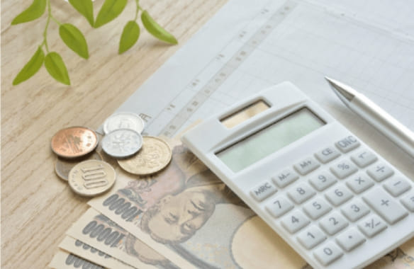 電卓とお金の画像